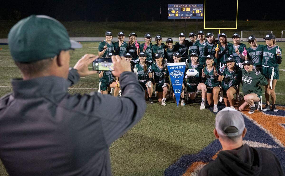 Ponderosa coach Tyson Escobar takes a photo of his team after the Sac-Joaquin Section Division II championship girls flag football game on Saturday at Cosumnes River College.