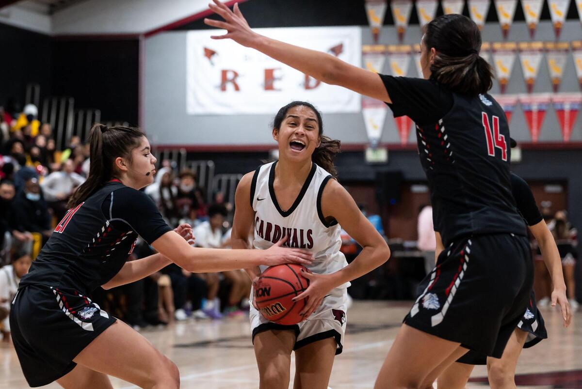 Laguna Creek guard Zoe Tillery (3), center, runs into trouble while trying to drive to the hoop past Folsom center Kamryn Mafua (14), right, and forward/center Emily Climenhage (21), left, during the first period of the high school girls basketball game Friday at Laguna Creek High School in Elk Grove.