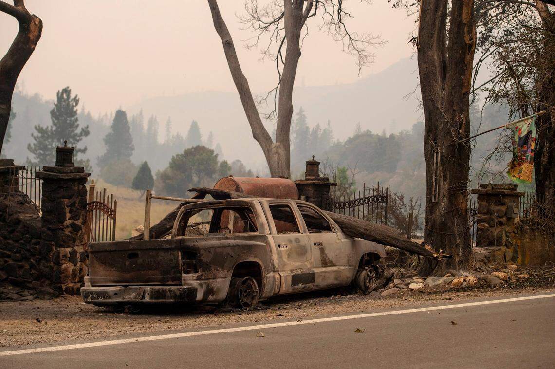A vehicle is scorched outside of what remains of a home along Highway 96 as the McKinney Fire burns in Klamath National Forest in Siskiyou County on Sunday.
