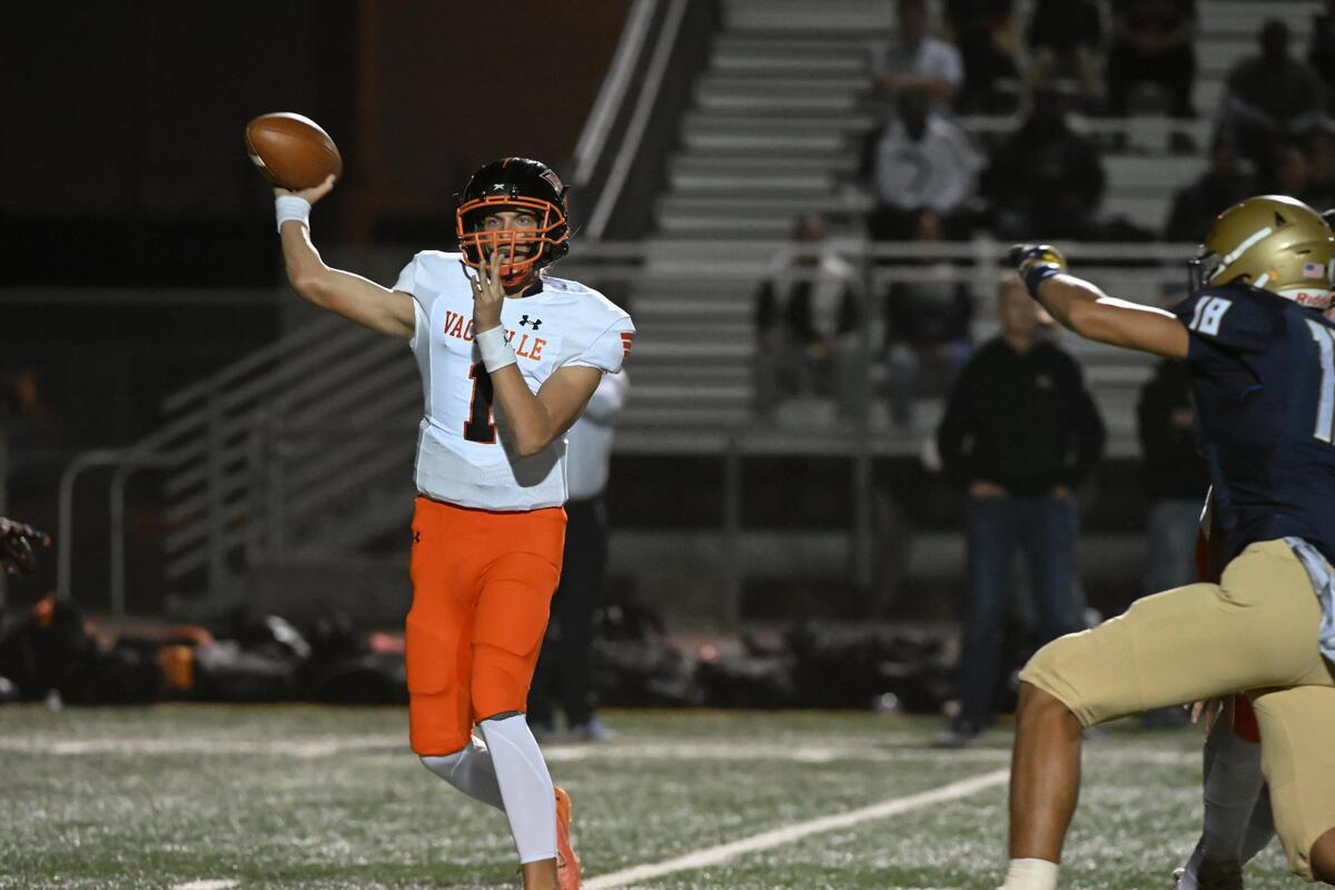 Vacaville Bulldogs quarterback Brody Fortunati (1) looks to pass with the Elk Grove Thundering Herd’s Lucan Amituanai (18) on defense in the first half of the first round of the CIF Sac-Joaquin Division II section football playoffs on Friday.