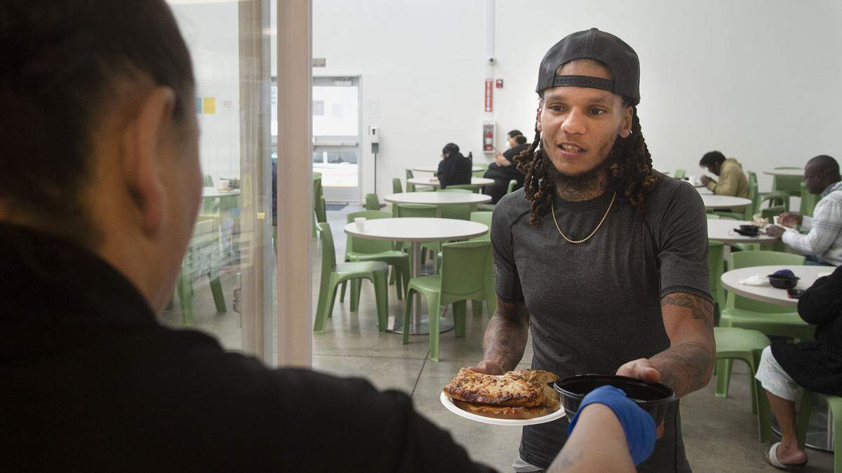 Tyrell Hamilton, 28, a guest at the Volunteer’s of America X-Street Navigation Center gets his lunch on Wednesday, Dec. 1, 2021, in Sacramento. The X Street Navigation Center is asking Book of Dreams for donations to buy a new refrigerator for guests to store their own food items.
