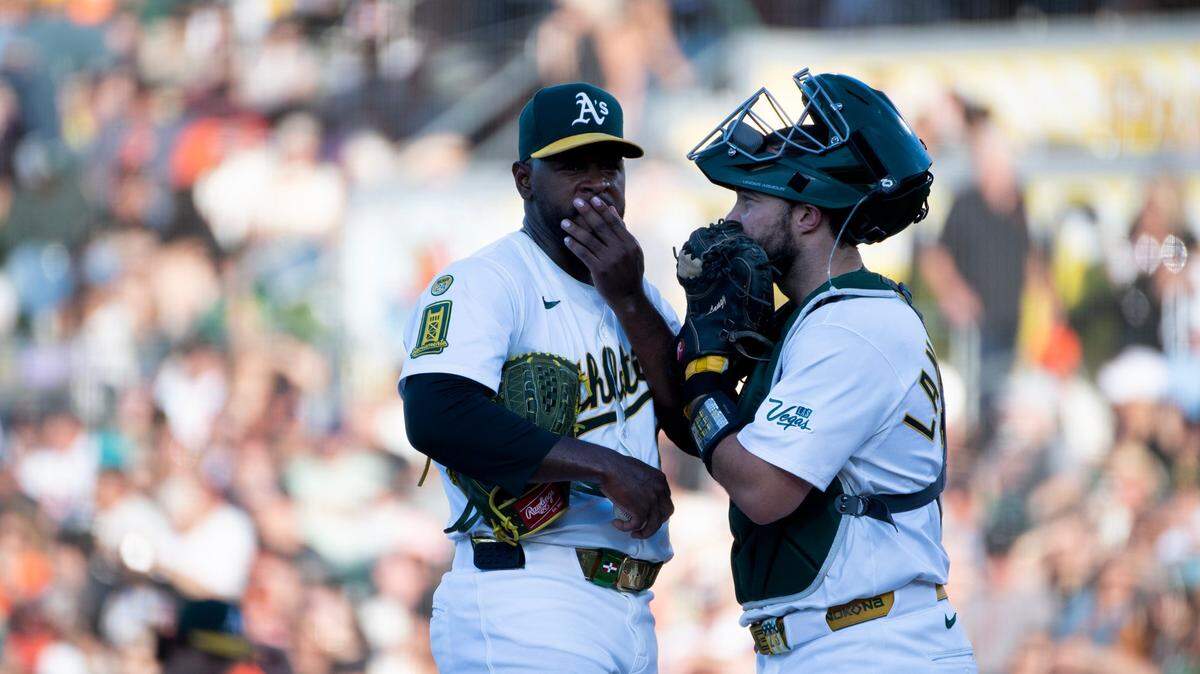 Athletics pitcher Luis Severino (40) talks with catcher Shea Langeliers (23) after loading the bases in the first inning in a game against the San Francisco Giants on Saturday at Sutter Health Park in West Sacramento.