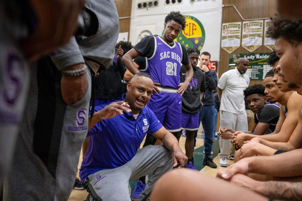 The Sacramento Dragons head coach Sidney Duplessis talks to his team before the start of the second half of a CIF Sac-Joaquin Section boys basketball playoff game against the Rio Americano Raiders on Wednesday in Sacramento.