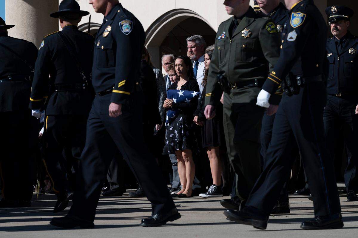 Jessica Lenehan holds a flag outside the funeral for her husband Elk Grove police officer Tyler Lenehan, 44, on Feb 1, 2022, outside Bayside Church Adventure Campus in Roseville. He died Jan. 21, following a traffic collision on Highway 99 near 47th Avenue in Sacramento.