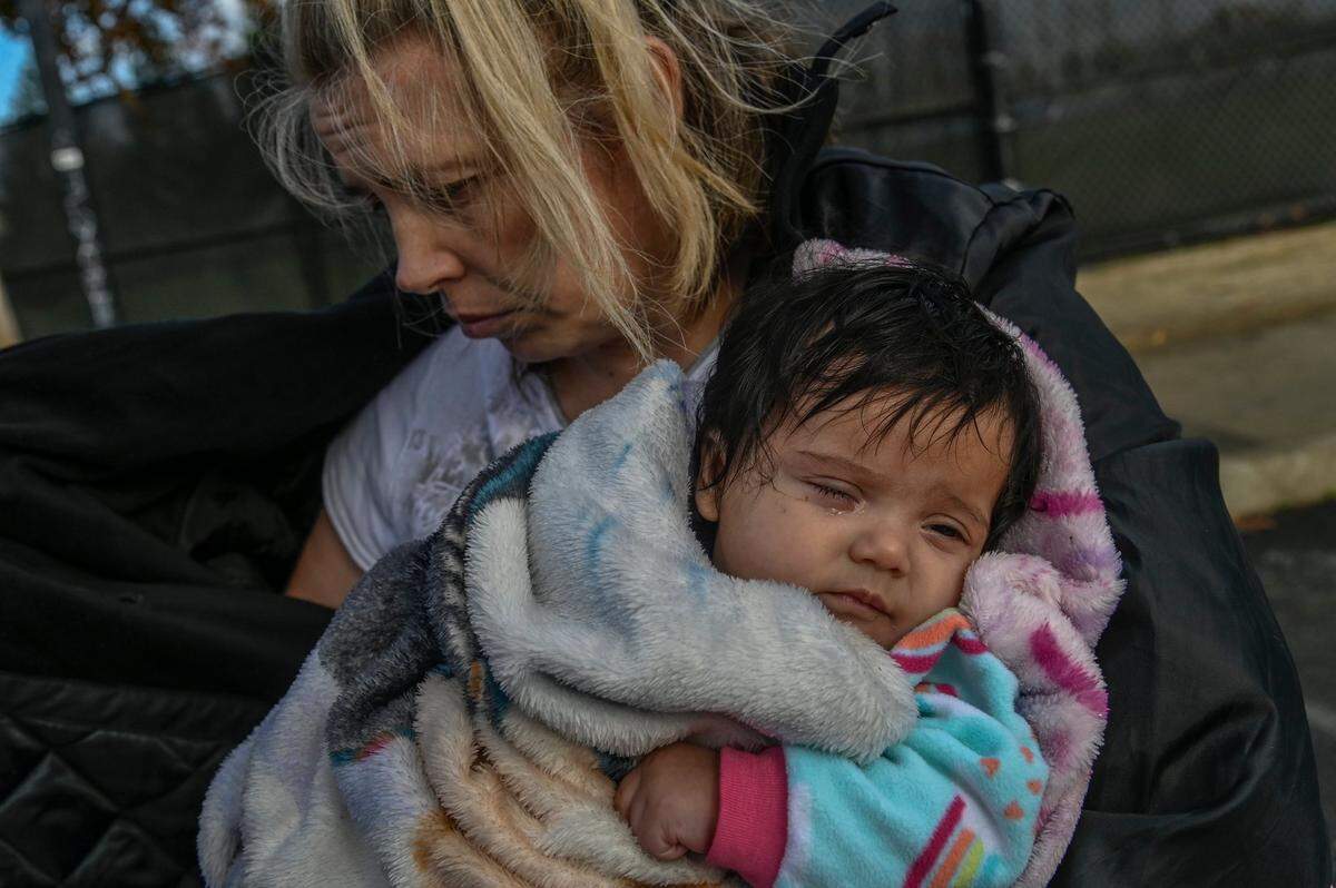 Geri Wells, 36, holds 3-month-old daughter Orion Gonzales in a park in Rancho Cordova on Thursday, Dec. 9, 2021. The homeless family of five had their motorhome towed away by the city last month and are struggling to survive living in an SUV. “My children are suffering for it. My birth certificates are gone — everything we owned was in that motorhome and the storage (unit) we lost the day before. We couldn’t save the storage because we couldn’t afford the money we had to give them,” said Wells.