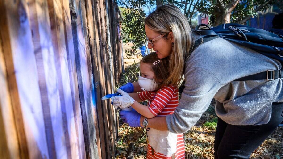 Lauren Sage ayuda a su hija, Scarlett Sage-Doro, de 4 años, a pintar con aerosol la valla en Oak Park Art Garden, en Sacramento, el domingo 24 de noviembre de 2019. La pared en Oak Park Art Garden es un espacio designado para el uso de pintura en aerosol.