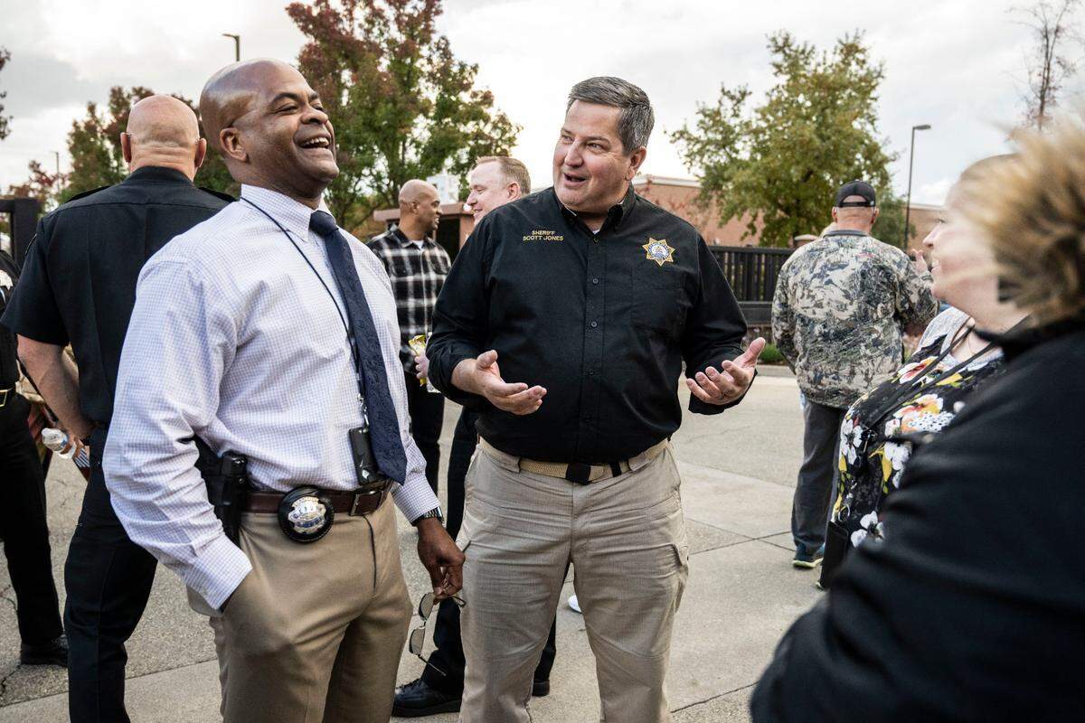 Outgoing Sacramento County Sheriff Scott Jones laughs with Rancho Cordova Police Chief Brandon Luke during a November farewell barbecue outside the sheriff’s office headquarters on Orange Grove Avenue.