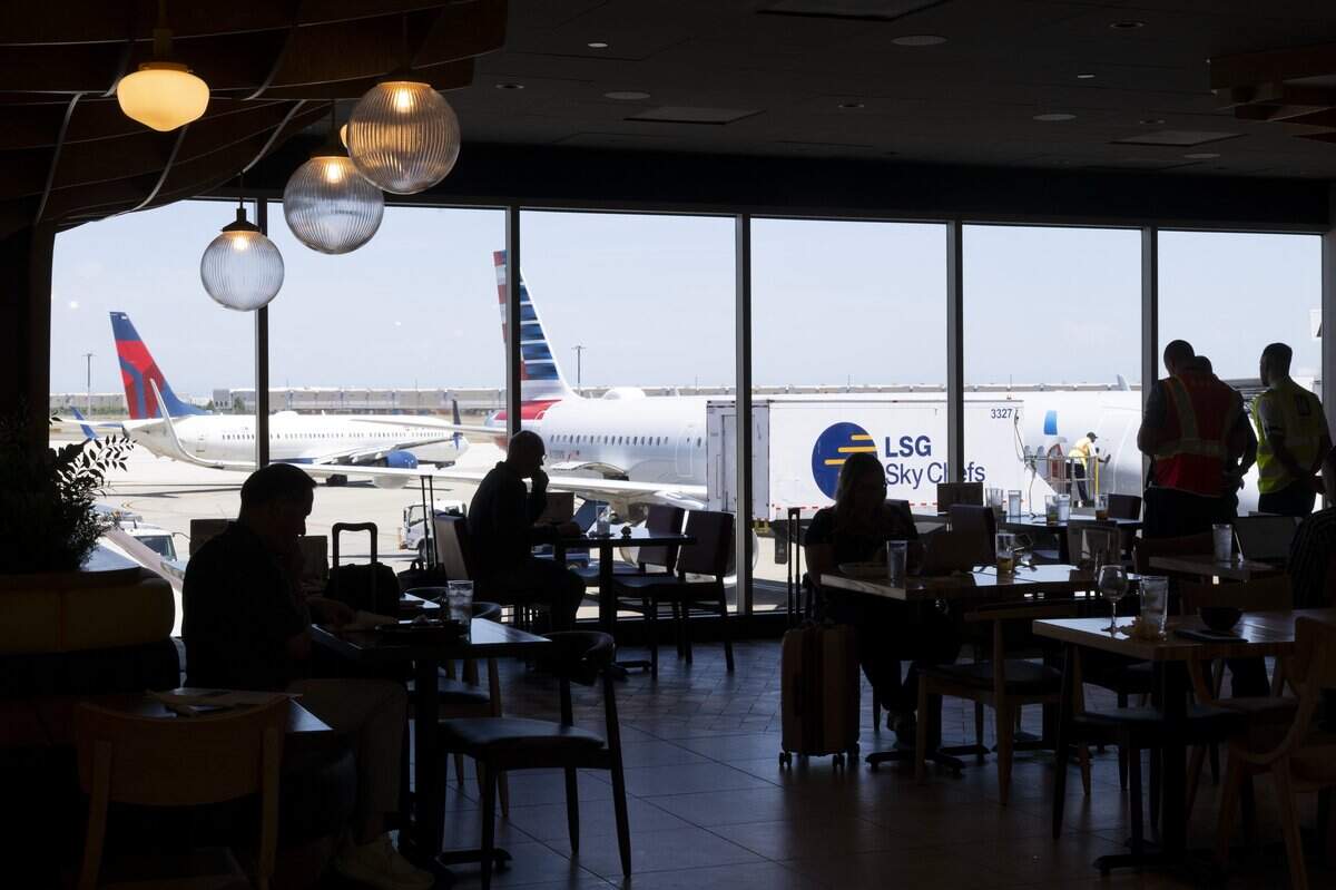 People sit in Magpie Café in terminal B at Sacramento International Airport, as airplanes taxi outside on Wednesday, June 17, 2026.