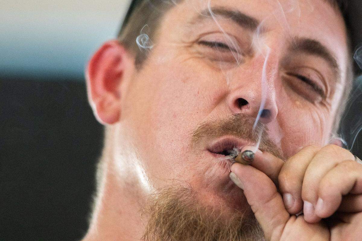 John Mitchell smokes a prerolled joint in the cannabis consumption lounge on Tuesday, July 16, 2024, during the California State Fair in Sacramento.
