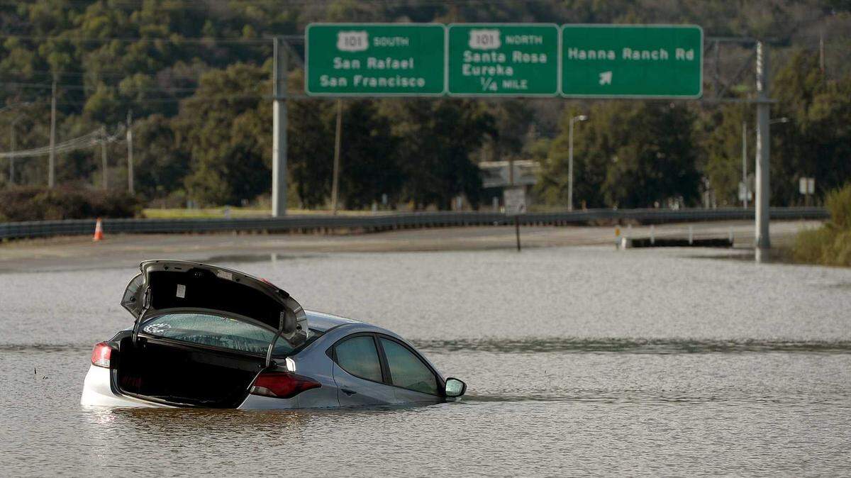 Floodwater surrounds a car stranded on Highway 37 near Novato after storms in January 2017. Flooding from levee failures and high tides has repeatedly shut down Highway 37, but Caltrans' $500 million interim project does not include measures to protect against similar future events.