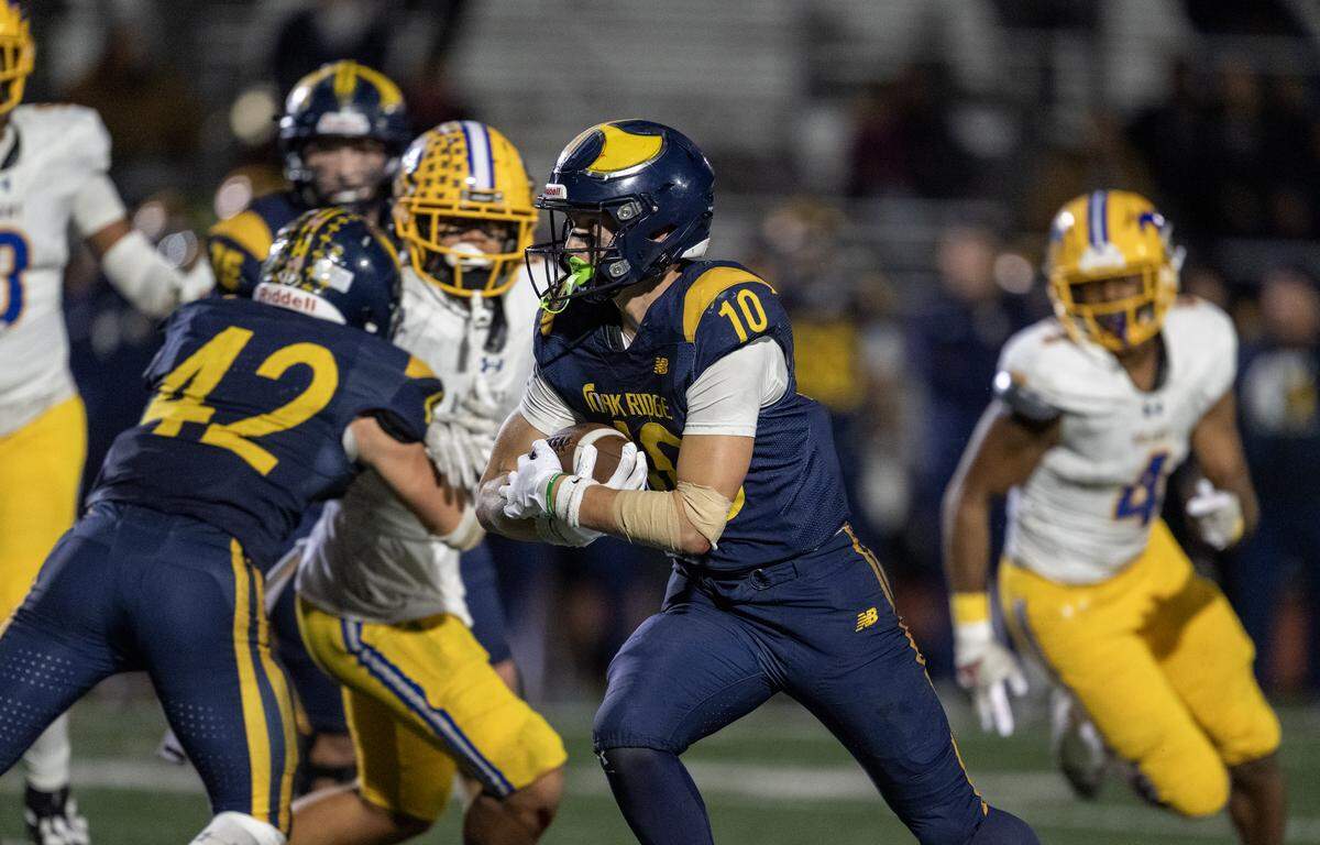 The Oak Ridge Trojans' Jasen Womack (10) runs through the Grant Pacers defense late in the second half in the CIF Sac-Joaquin Section Division l semifinal football playoff game in El Dorado Hills on Friday.