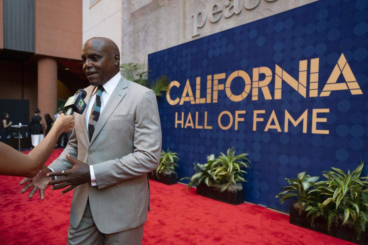 Athlete Carl Lewis talks to reporters as he walks the red carpet before an induction ceremony of the 19th class of California Hall of Fame inductees at the California Museum in Sacramento on Thursday.