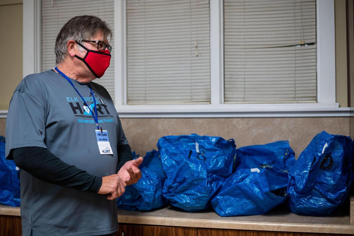 Mark Hedlund, Elk Grove Homeless Assistance Resource Team lead at Elk Grove United Methodist Church, describes how the bags seen behind him help keep people’s belongings and bedding separate at the recently opened Elk Grove Overnight Warming Center, on Friday, Dec. 10, 2021, at 8986 Elk Grove Blvd.