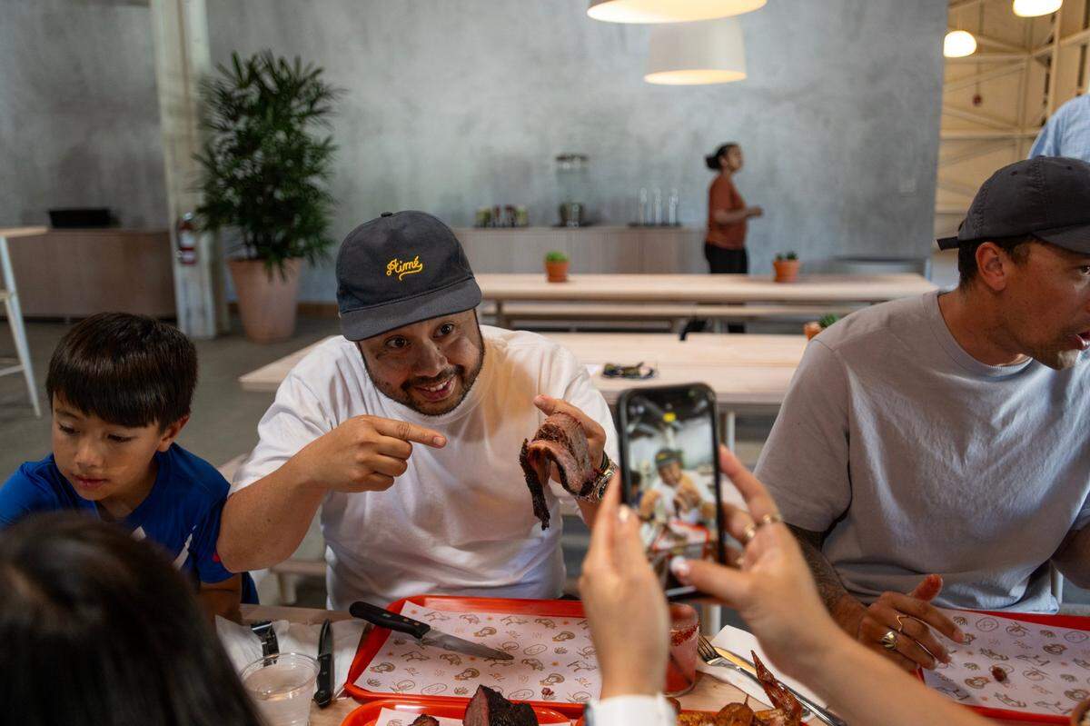 Ricky Yap shows off a slice of brisket at Slow & Low Smokehouse’s soft opening on Wednesday.