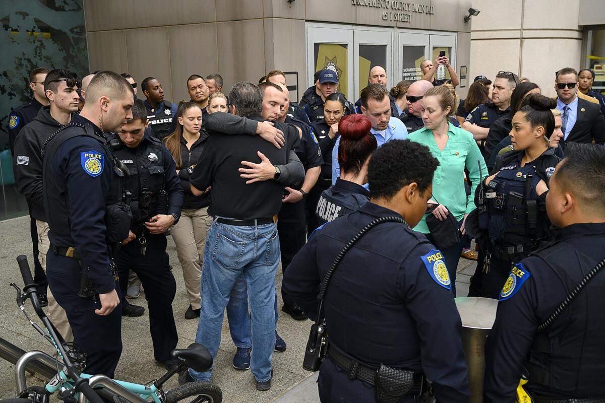 Denis O’Sullivan, back to camera, father of slain Sacramento Police officer Tara O’Sullivan, hugs a law enforcement officer who came to support the family as the prosecutor sought the death penalty of her accused killer Adel Ramos in Sacramento Superior Court on Thursday, Jan. 23, 2020.