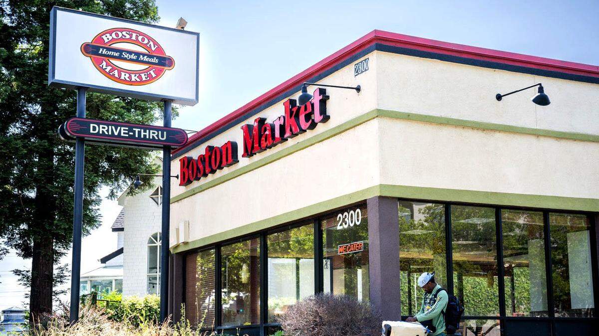 Quenns Pickett of Sacramento adjusts his audio equipment as he rides in front of the lone remaining Boston Market restaurant in Sacramento County on Thursday, June 8, 2023.