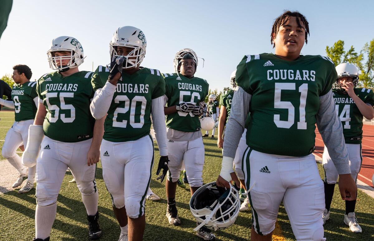 Kennedy’s Jude Antwi, center, walks with teammates before their game against River City during the high school football game Thursday, April 15, 2021, at John F. Kennedy High School in Sacramento. Jude’s older brother, Manny Antwi, died during their home opener in March 2020.