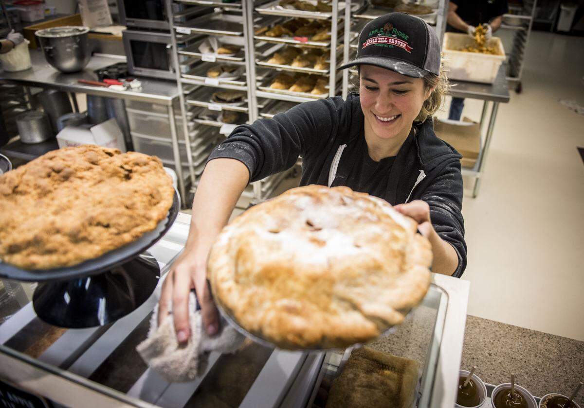 Hailey Sota places an apple pie on a counter at Apple Ridge farms in Camino in 2018.