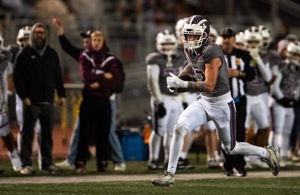Woodcreek Timberwolves tight end Tilden Hull (13) takes a reception down the sideline against the Rio Americano Raiders in the second quarter of a CIF Sac-Joaquin Division III semifinal playoff game in Roseville on Friday, Nov. 21, 2025.