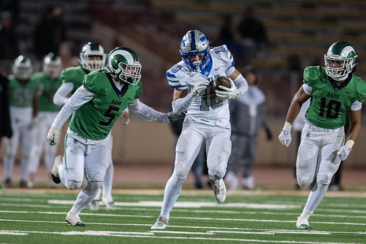 The Rocklin Thunder’s Gavin Correia (10) protects the ball after a catch pursued by St. Mary’s Rams strong safety Brennan Carr (5) and middle linebacker Jaden Jimenez (10) in the second half of the CIF Sac-Joaquin Section Division II football championship game on Saturday at Hughes Stadium.