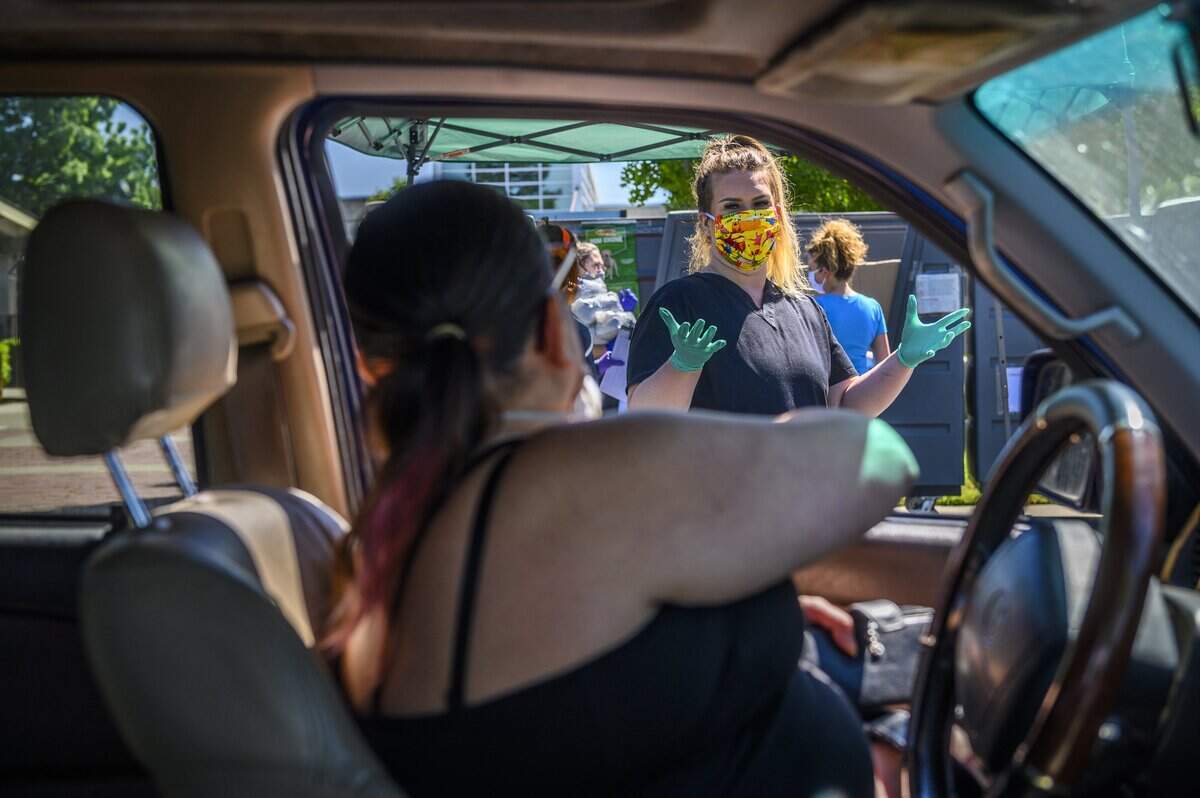 Sacramento SPCA member Dayna Hutchinson talks to woman picking up pet food at the organization’s headquarters on Florin Perkins Road in Sacramento, Tuesday, April 28, 2020. The emergency pet food bank, known as Paw Pantry, is open Tuesdays and Fridays to provide supplies for pet owners struggling financially in the coronavirus pandemic.