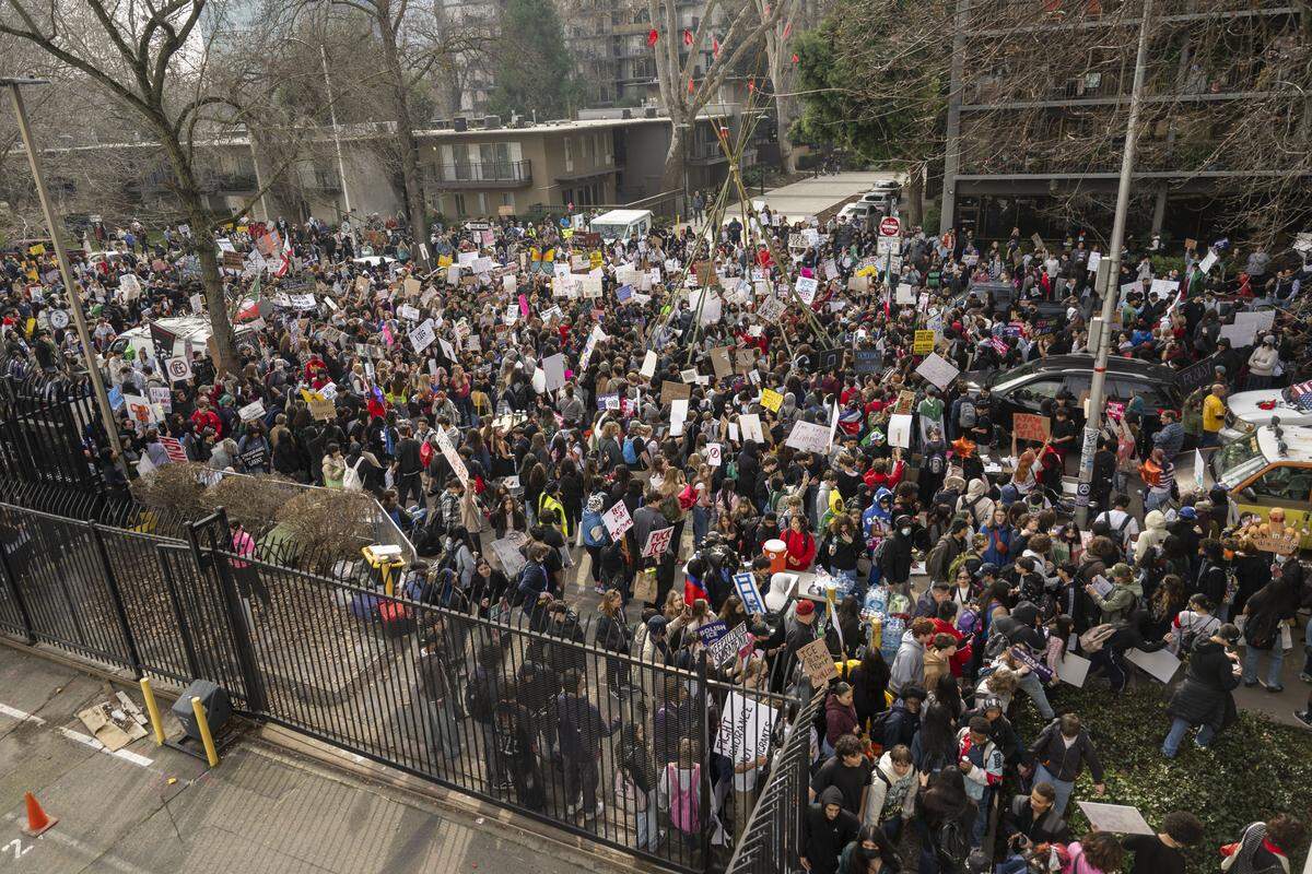 A large group of student protesters gather behind the John E. Moss Federal Building during a demonstration against ICE on Friday.