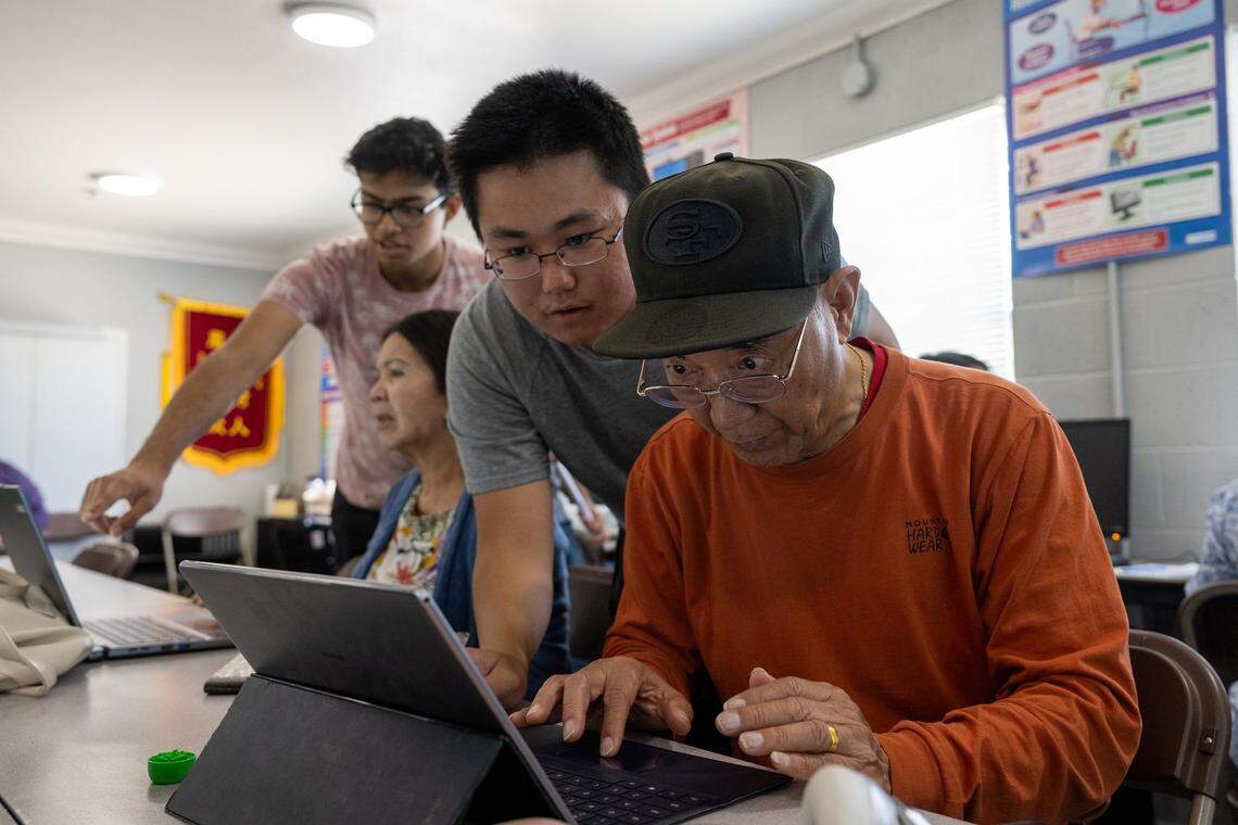 Sacramento Sate student Sheng-Chang Chen helps Leonard Zhong, 75, create a PDF during a digital literacy class last month at Asian Resources Inc. in Sacramento. Sac State digital navigators — students trained to teach digital literacy — help residents of the Lemon Hill neighborhood gain command of computer skills that will help them at home and in the workplace.