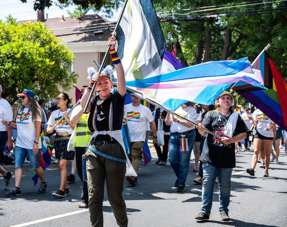 A parade participant waves a flag at the Sacramento Pride March on June 15, 2025.