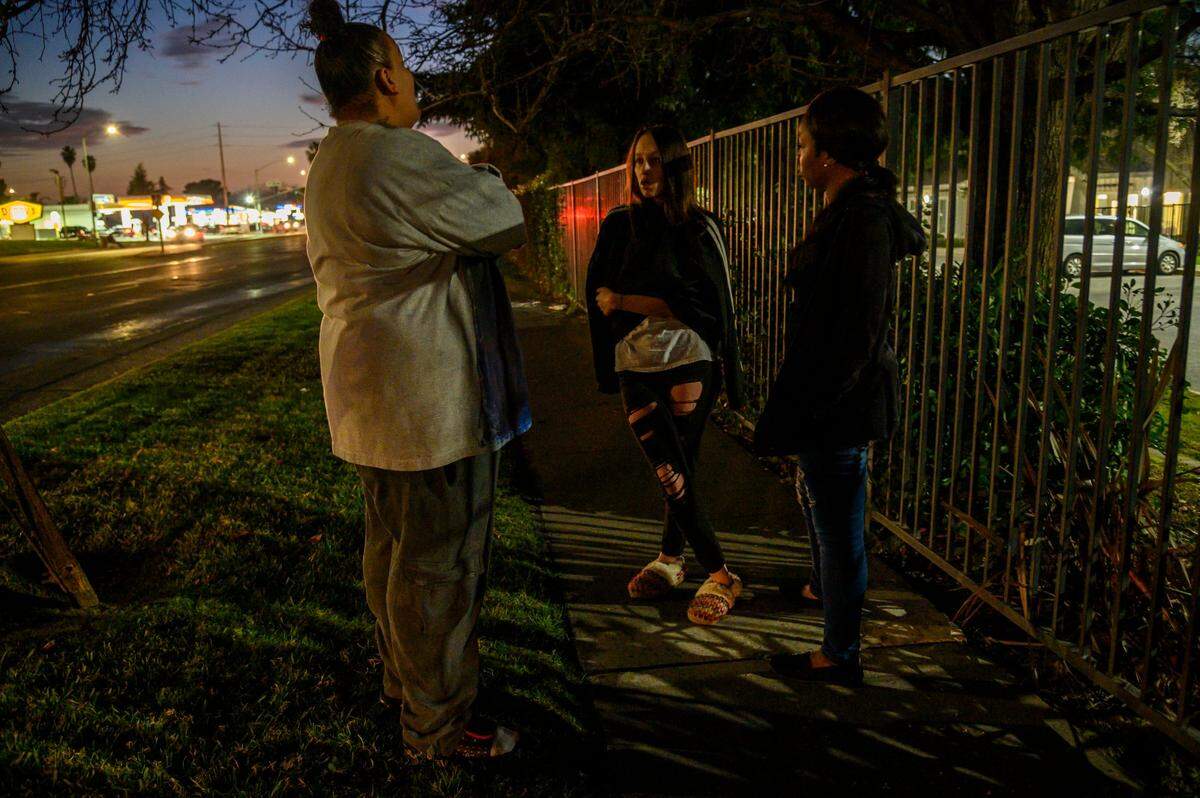 Felicia Clark, left, speaks to her daughter Angelica, center, outside the Children’s Receiving Home in Sacramento in January. “I sit out here and I protest to let her know that I’m here and I care, but it just sucks,” she said, wiping a stream of tears. “It’s just wrong when a child can go and hide in a place, and be mad at their mom for their mom not letting them run the streets and do drugs.