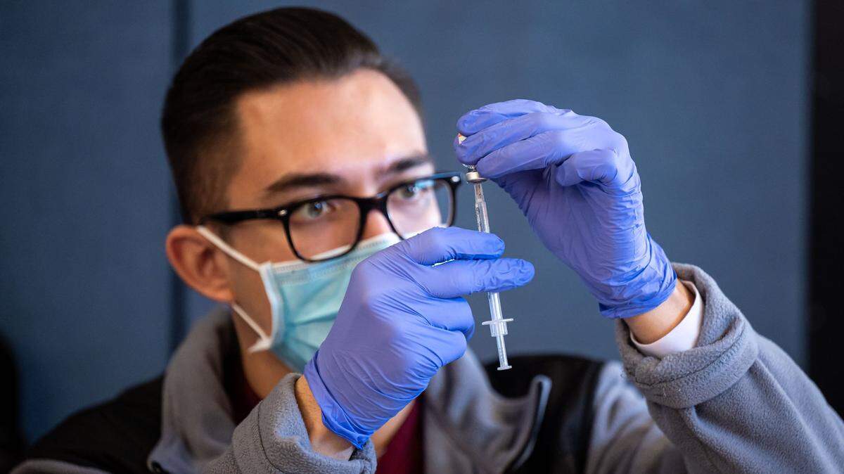 A nurse prepares a COVID-19 vaccine dose