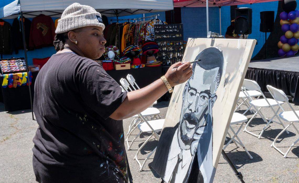 Artist Taylor Pannell works on a portrait of Malcom X in May at the inaugural Malcolm X Festival. Pannell did not receive any CARES Act funding.