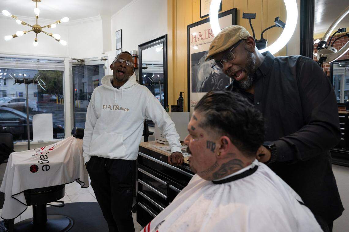 Marichal Brown, right, talks with customer Joe Chavarria with his brother Rodney Brown, left, at HAIRitage Salon on Feb. 29. They are part of a growing national network of Black barbers and stylists who have become frontline mental health advocates in their communities as part of the Confess Project.