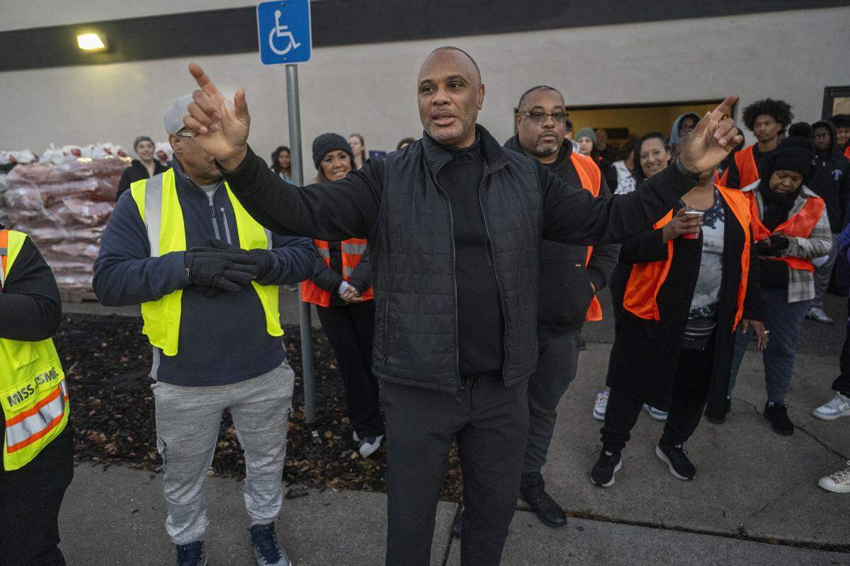 Pastor Les Simmons gives instructions to volunteers during a Thanksgiving meal distribution at South Sacramento Christian Center on Saturday.