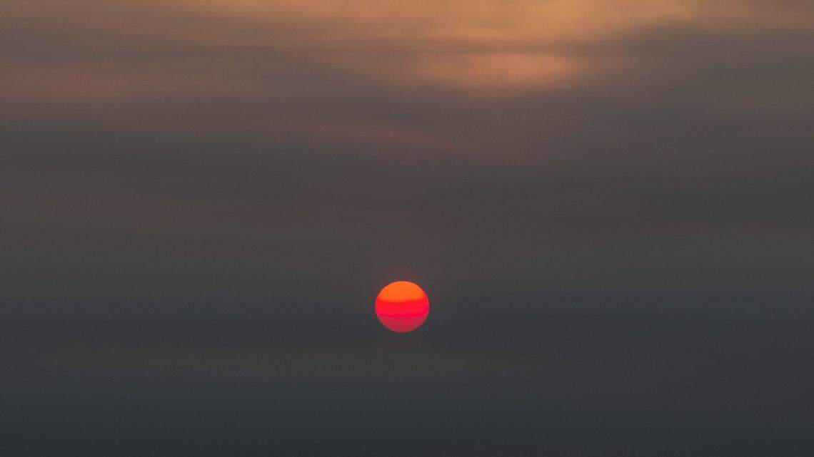 The sun sets in the west into a smoke-filled horizon from the County Fire in Yolo and Napa counties on July 1, 2018.