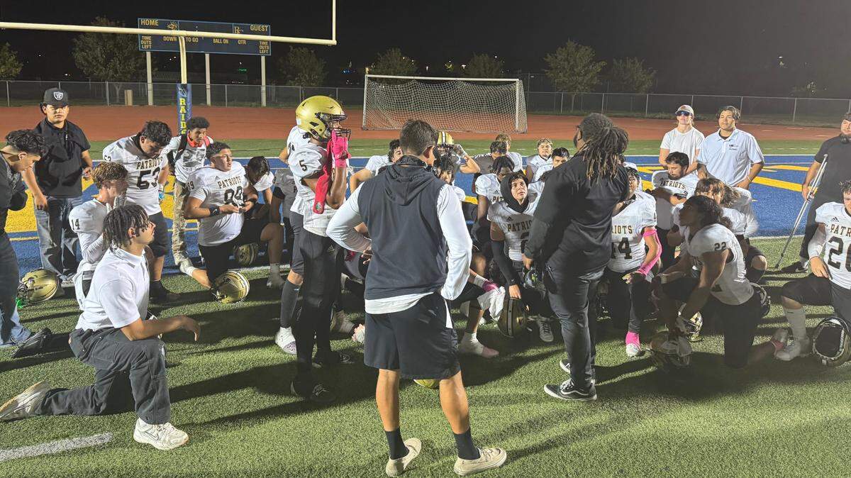 The Pioneer Patriots of Woodland kneel after a 14-10 victory over the River City Raiders on Friday in West Sacramento.