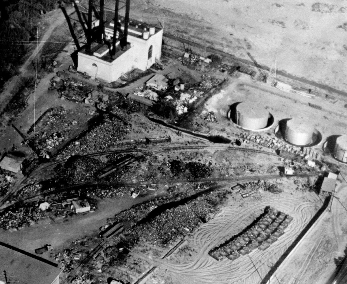 The PG&E powerhouse, known as River Station B during its operation from 1912 to 1954, stands in a 1950s aerial image next to the Associated Metals Company scrap metal yard on Jibboom Street in Sacramento. AMC purchased the powerhouse in 1957, but the property was acquired by Caltrans in the 1960s for the construction of Interstate 5.