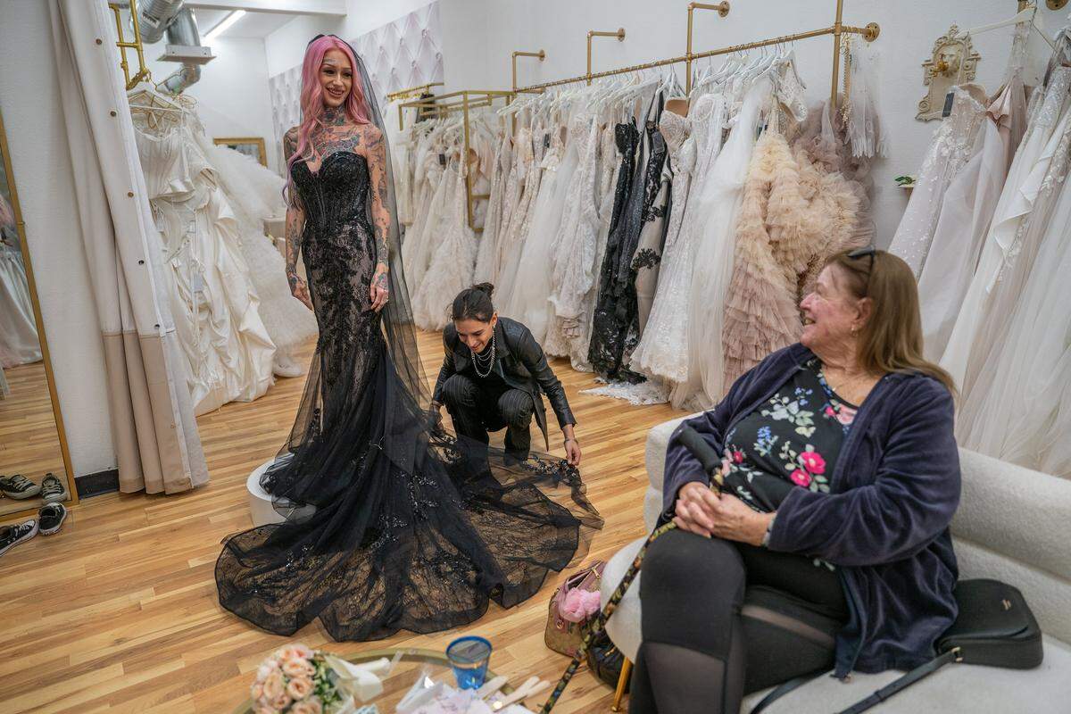 Erika Pringle smiles as Victor Seballos at Bridal Box in Roseville helps her during a fitting on Nov. 18 decide on a black wedding dress for her April wedding with her mother, Cheryl Pringle. Erika chose the birthday of her late brother Andrew Pringle as the wedding date; he died in 2023 after being hit by a driver who ran a red light in Rosemont.
