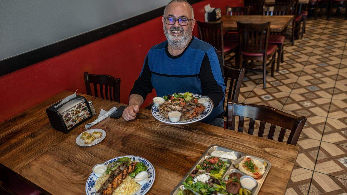 Walid Matar, owner of Wallys Cafe in Rocklin, holds one of his favorite meals to try, Chicken and Beef Shawarma, on Tuesday, Feb. 9, 2021. Also, featured on the table are a veggie sampler and chicken and lab kabobs. All his meals include complimentary homemade lentil soup and baklava for desert. His authentic Lebanese & Mediterranean cuisine is all homemade.
