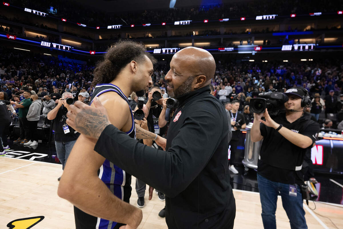 Sacramento Kings rookie guard Devin Carter (22), making his NBA debut after recovering from a shoulder surgery, is embraced by his father, Memphis Grizzlies assistant coach Anthony Carter, on Friday at Golden 1 Center.