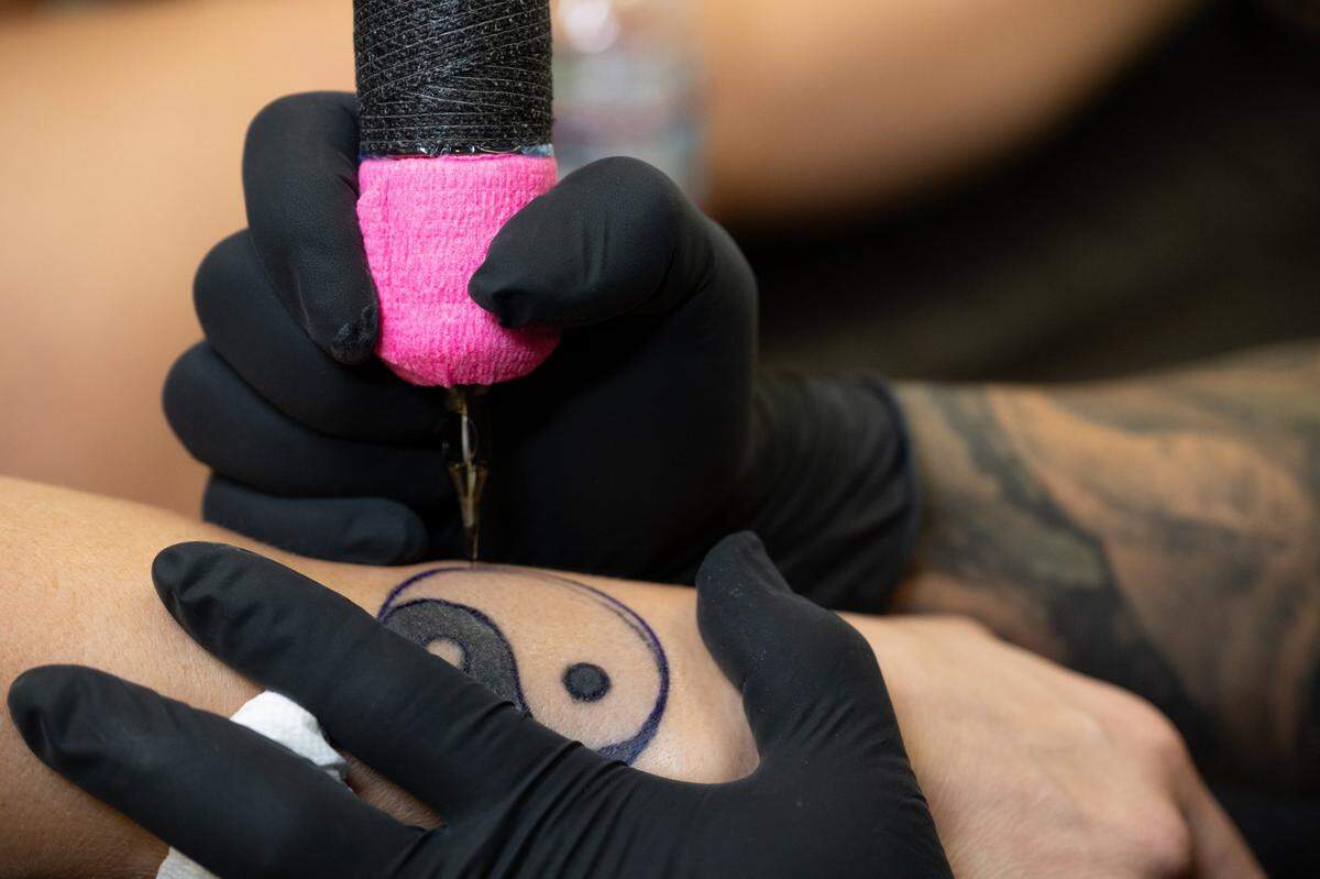 Tattoo shop owner Edgar Avila touches up a tattoo by another tattoo artist for customer Sarah Duplantier at Elk Grove Tattoo earlier this month.