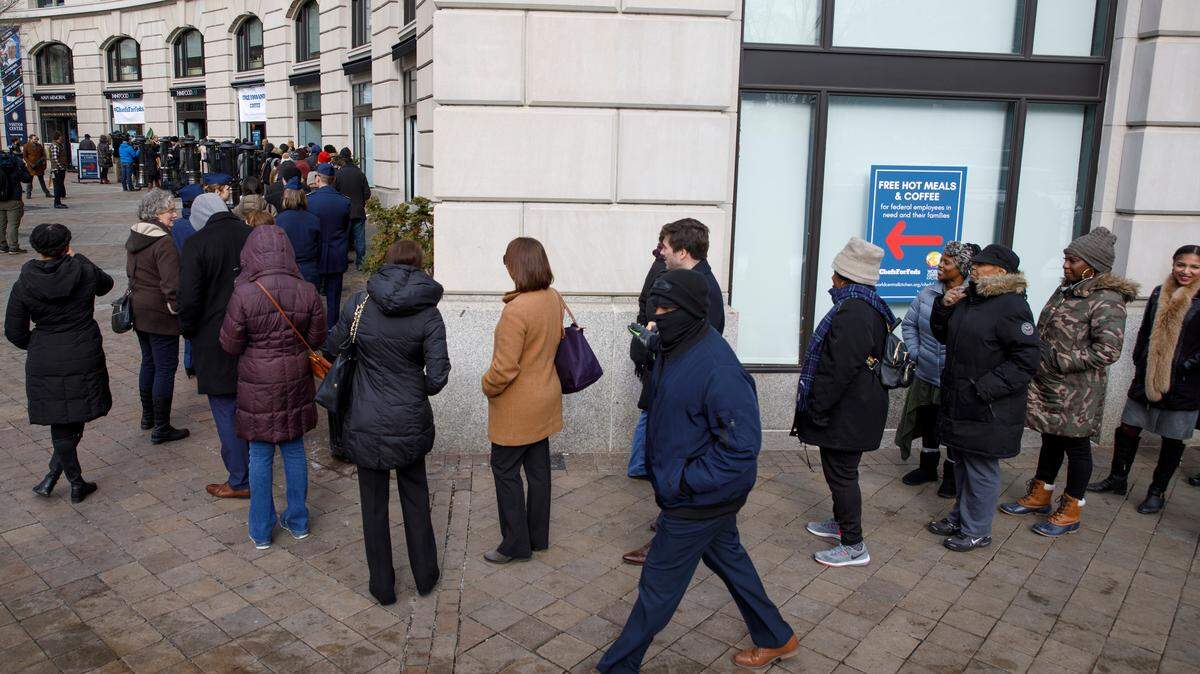 FILE-- Furloughed federal workers line up for meals at a relief site run by the nonprofit World Central Kitchen in Washington on Wednesday, Jan. 16, 2019. The five-week federal government shutdown cost the U.S. economy $11 billion, with nearly a quarter of that total permanently lost, the Congressional Budget Office said on Jan. 28. (Tom Brenner/The New York Times)