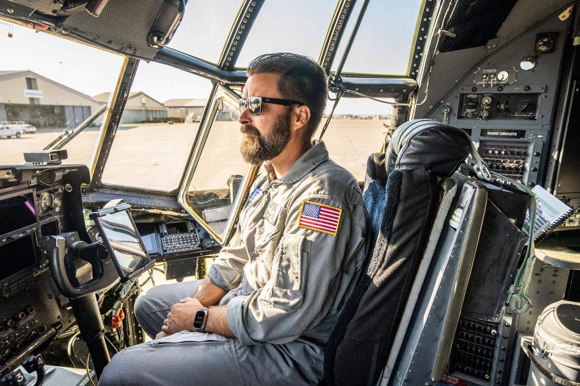 Jeremy Sweitzer, a lead C-130 flight engineer for Cal Fire, sits in the cockpit as he gives a tour of the newly converted air tankers on Thursday at McClellan Airport.