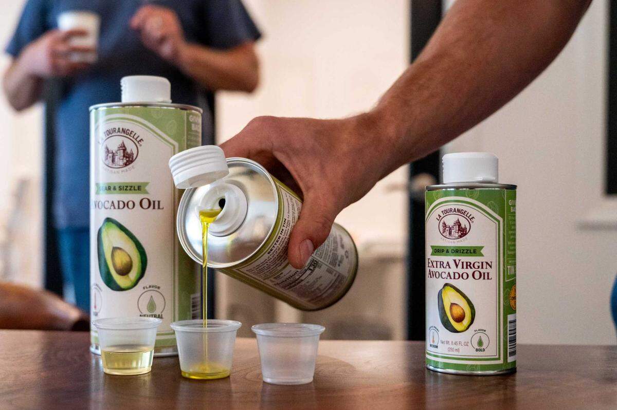 Marketing coordinator Lucas McMaster pours avocado oil into sample cups at La Tourangelle Artisan Oil Mill in Woodland on Monday, July 7, 2025.
