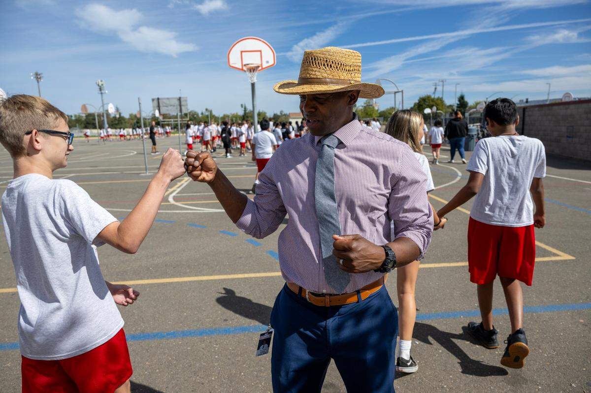 Principal Tarik McFall fist-bumps a student at Sutter Middle School in Folsom on Thursday. The school has banned cell phones during school hours, including lunch, since 2022.
