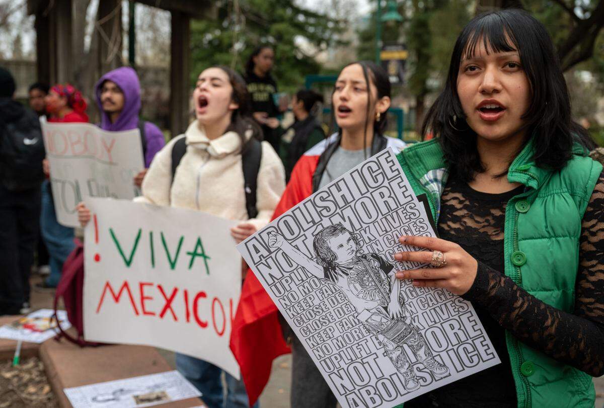 Christina Rosales, right, stands with Carmen Andrade, center, and Selene Lopez, left, as Sacramento State students protest Tuesday demanding the university establish a sanctuary and not share information about undocumented students with ICE.