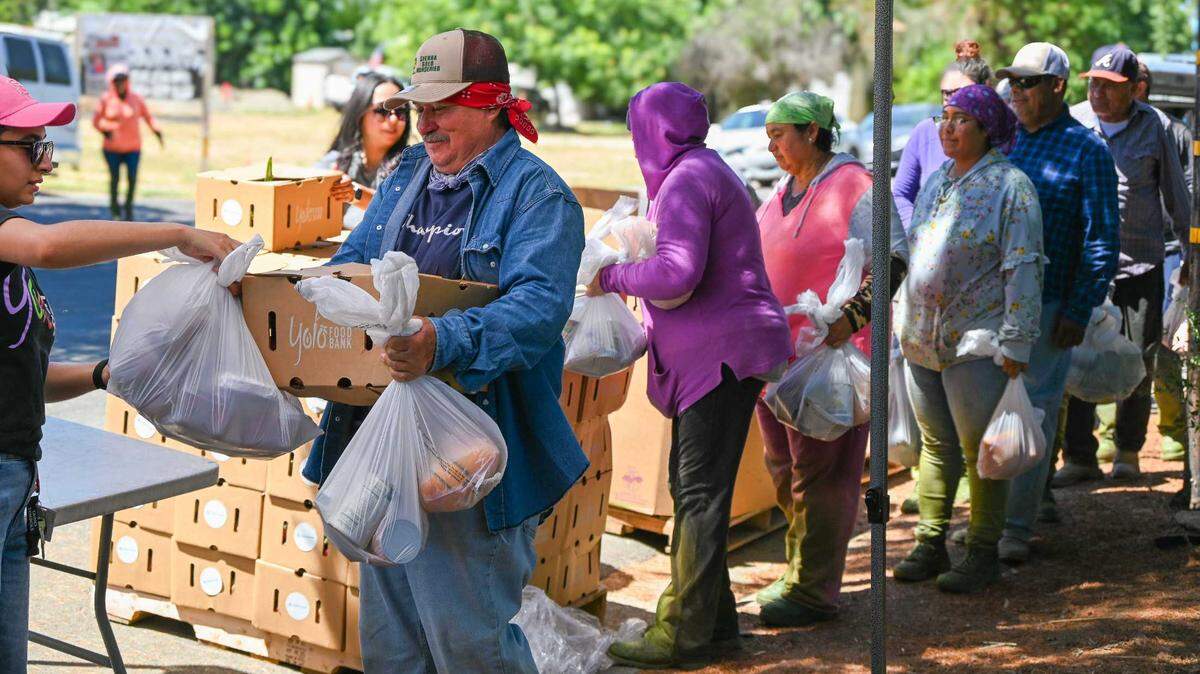 Residents line up to receive food from the Yolo County Food Bank. The vital service is facing a steep budget cut this year after the federal government slashed federal dollars flowing to local food banks.