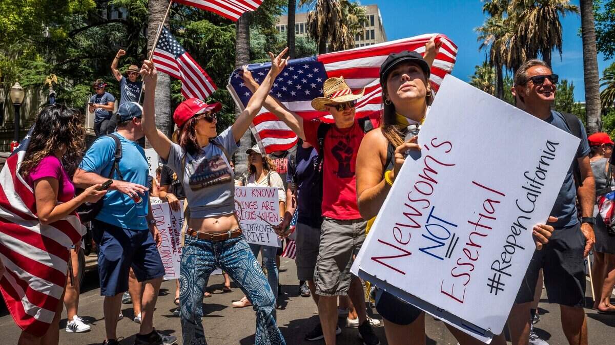Demonstrators dance to live music during on 10th Street near the west steps of the Capitol in downtown Sacramento, Calif. on Saturday, May 23, 2020. At least 2,000 demonstrators protested near the Capitol on Saturday to call for California Gov. Gavin Newsom to lift coronavirus related restrictions.
