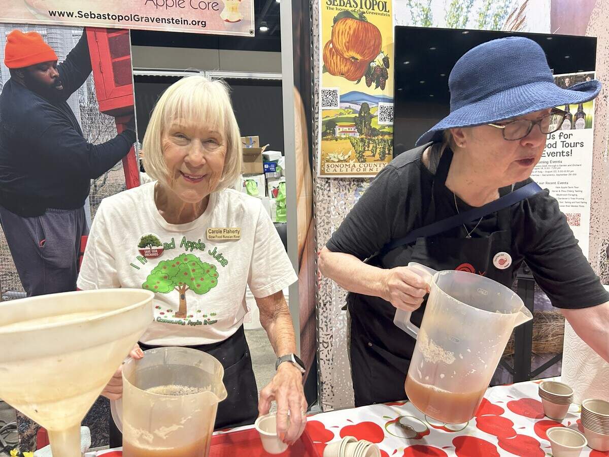Carole Flaherty, left, and Eileen Maloy, right, pour fresh juice at the Slow Food Russian River booth for the Terra Madre Americas event  Saturday in Sacramento.