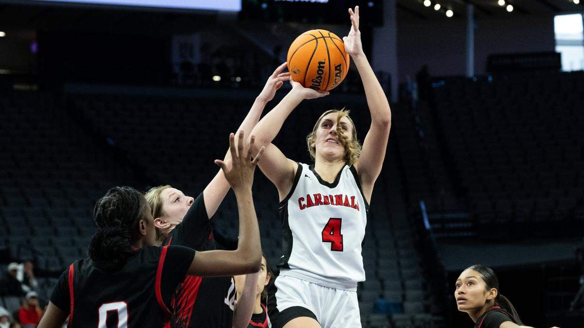 The Woodland Christian Cardinals’ Teagan Hayes is fouled by the Rosamond Roadrunners’ Kiley Perez during the CIF Division V State Championship girls basketball game at Golden 1 Center on Friday.