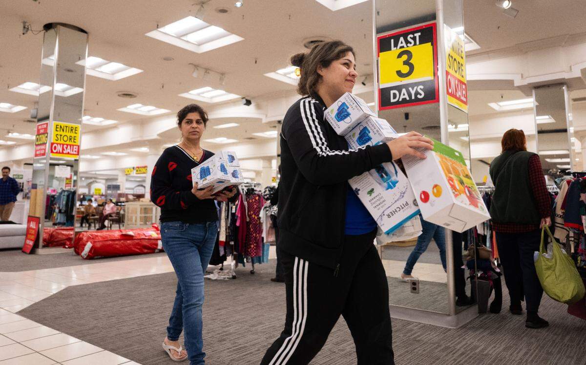 Customers carry their purchases at the Downtown Commons Macy’s store in Sacramento on Thursday.